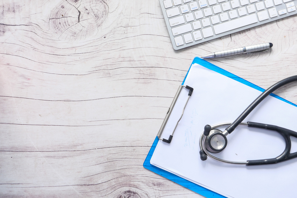 Doctors Workplace with Container, Keyboard and Prescription on Desk.