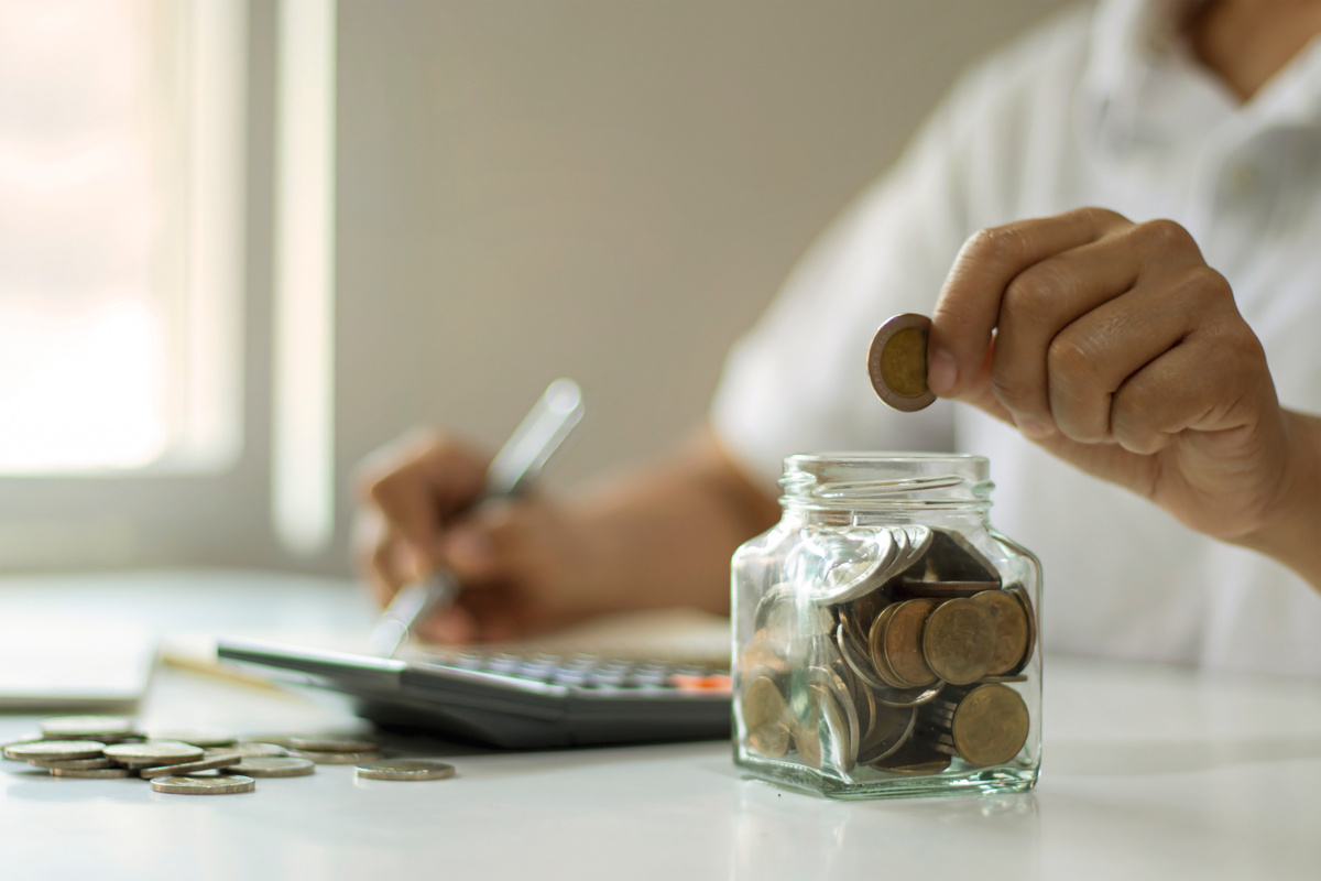 Person Saving Coins in a Jar