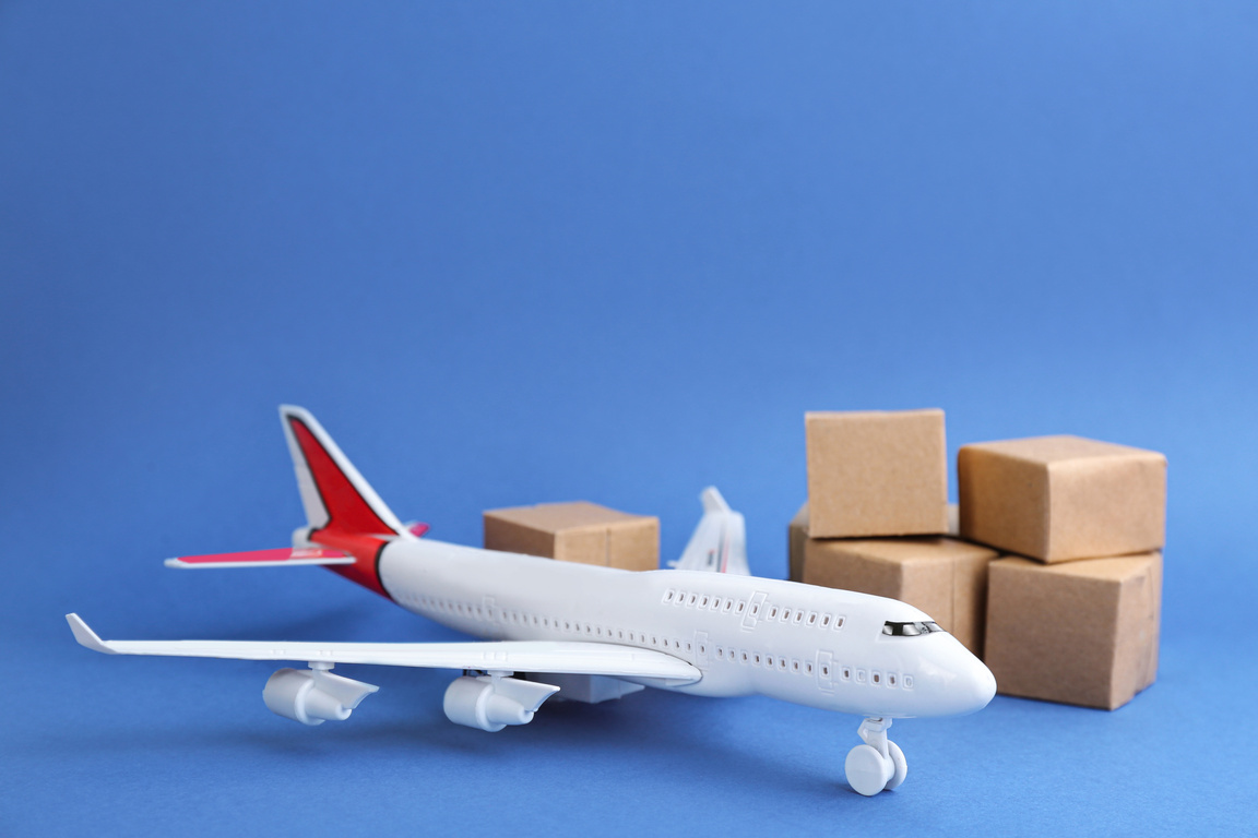 Airplane Model and Carton Boxes on Blue Background. Courier Serv